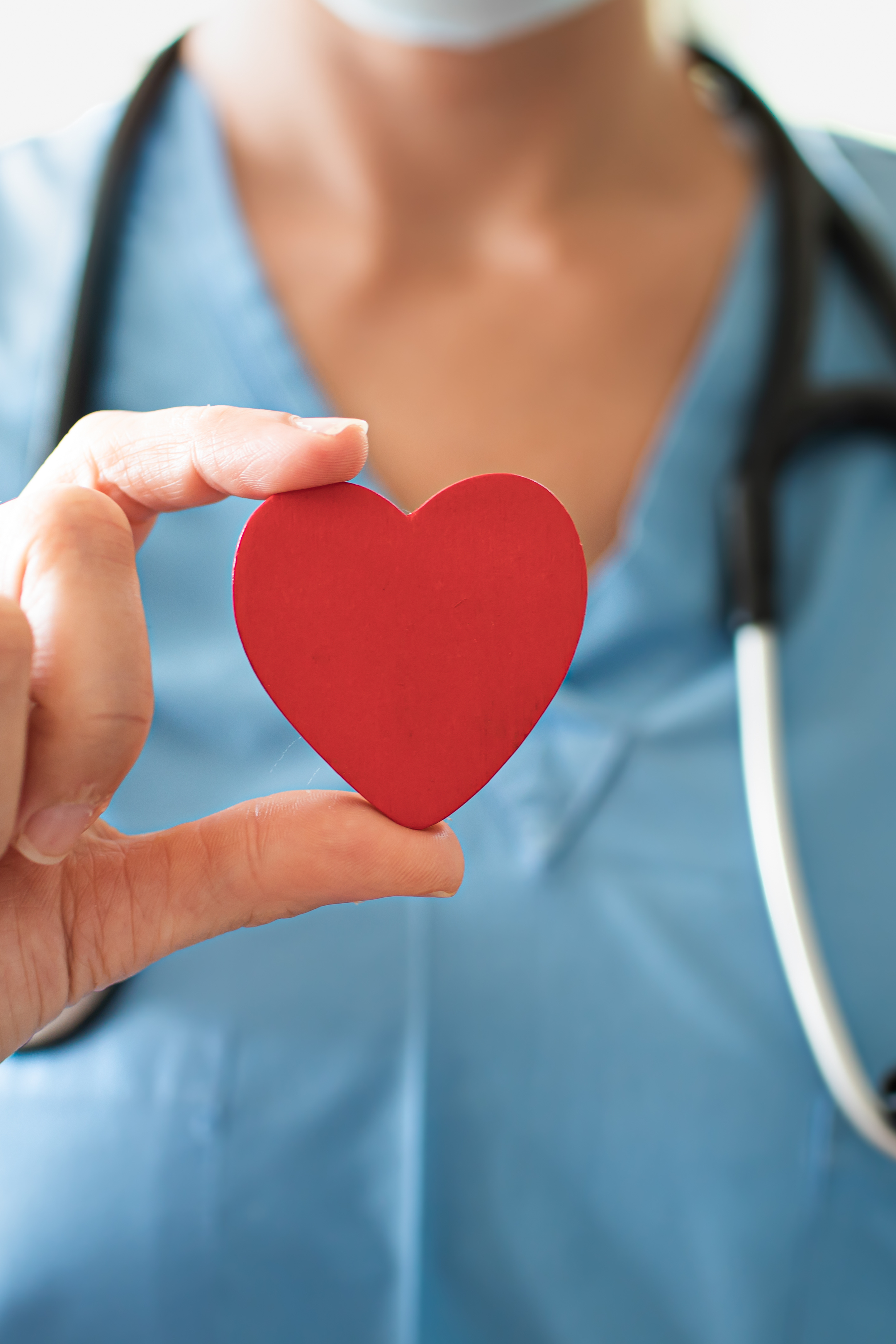 pracownik medyczny trzymający w dłoni czerwony symbol serca