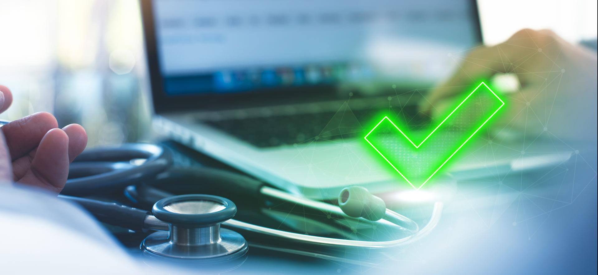 zielony znak check na tle laptopa