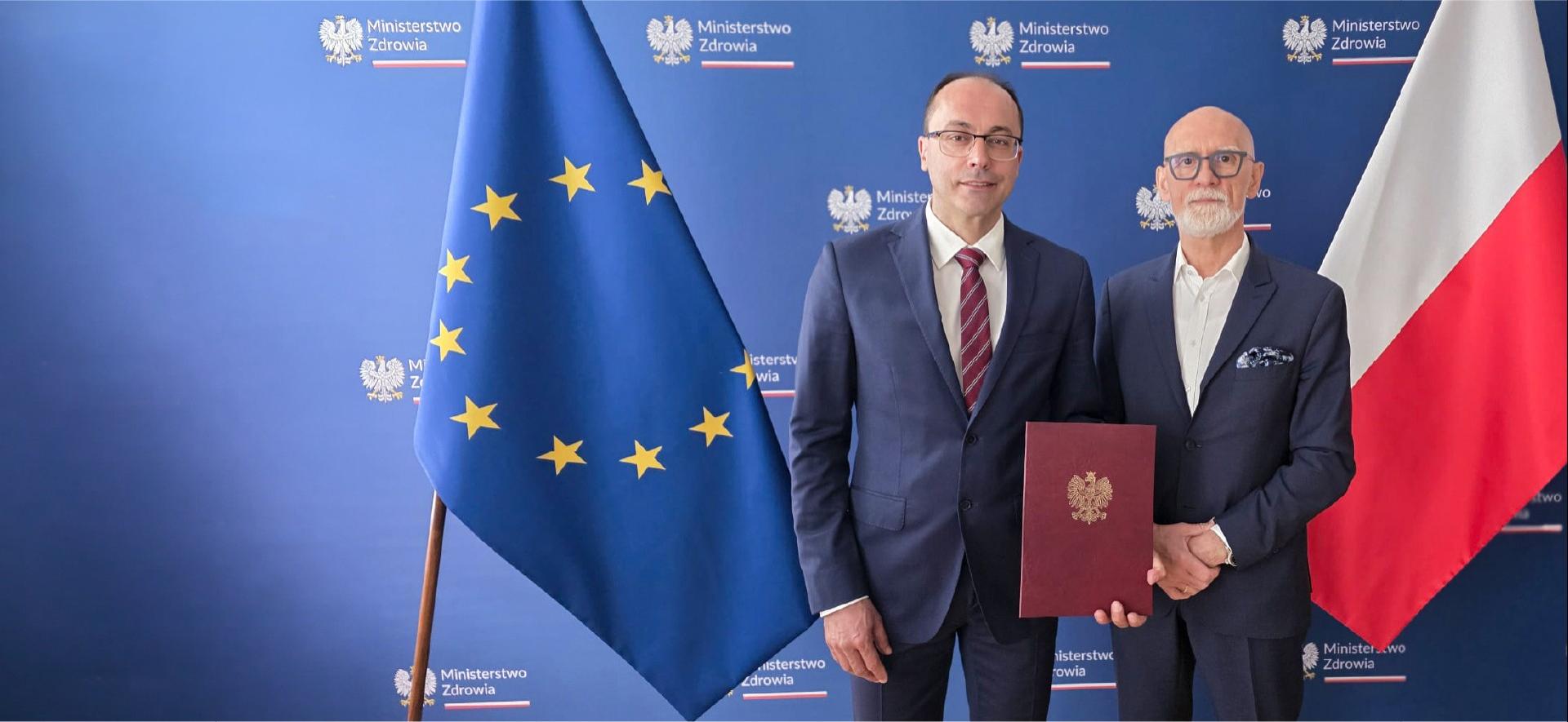 dyrektor CeZ na tle flag unijnej i polskiej