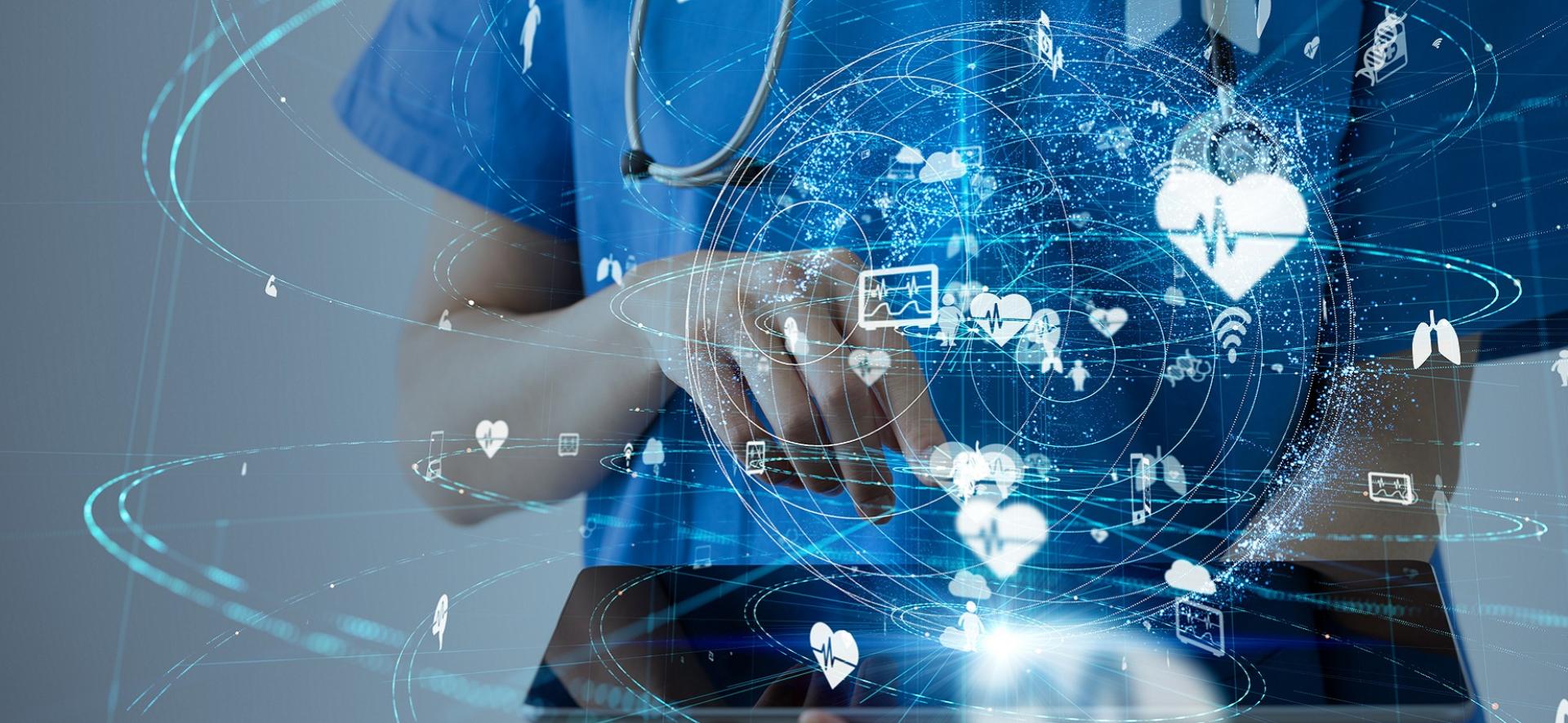 lekarz z tabletem w ręku, wokół wyświetlają się wirtualne ikony przedstawiające usługi e-zdrowia