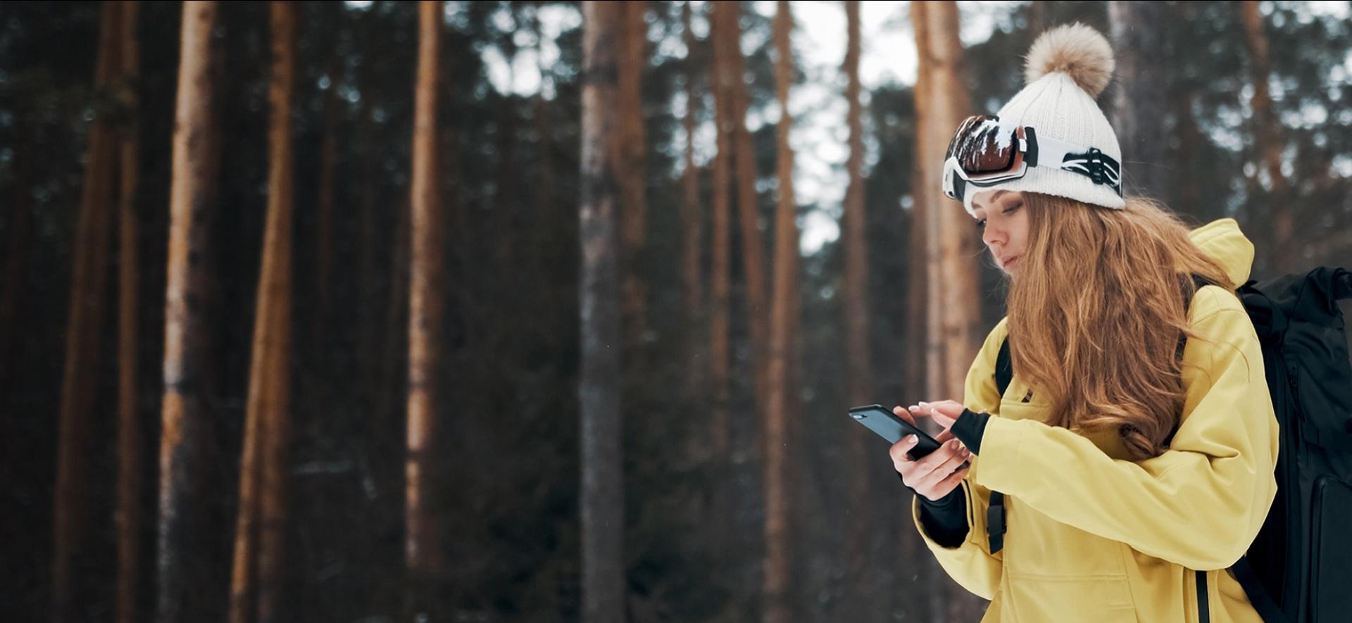 dziewczyna w żółtej kurtce patrząca na telefon