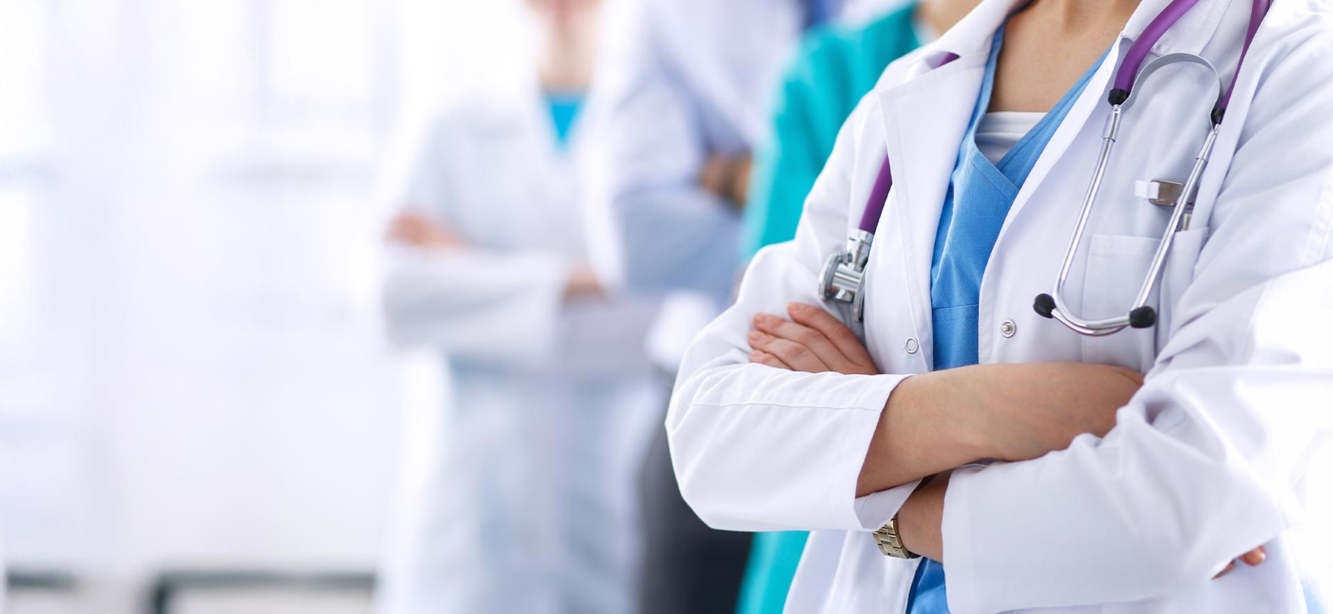 lekarze i lekarki stojący w rzędzie