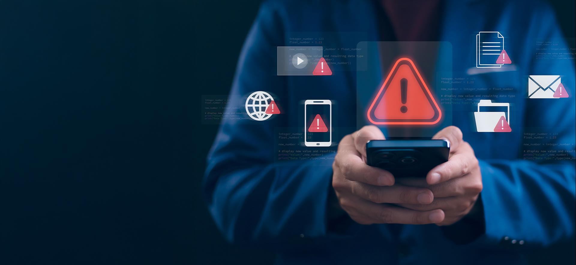 człowiek trzyma telefon, a nad nim unosi się ikona czerwonego trójkąta z wykrzyknikiem