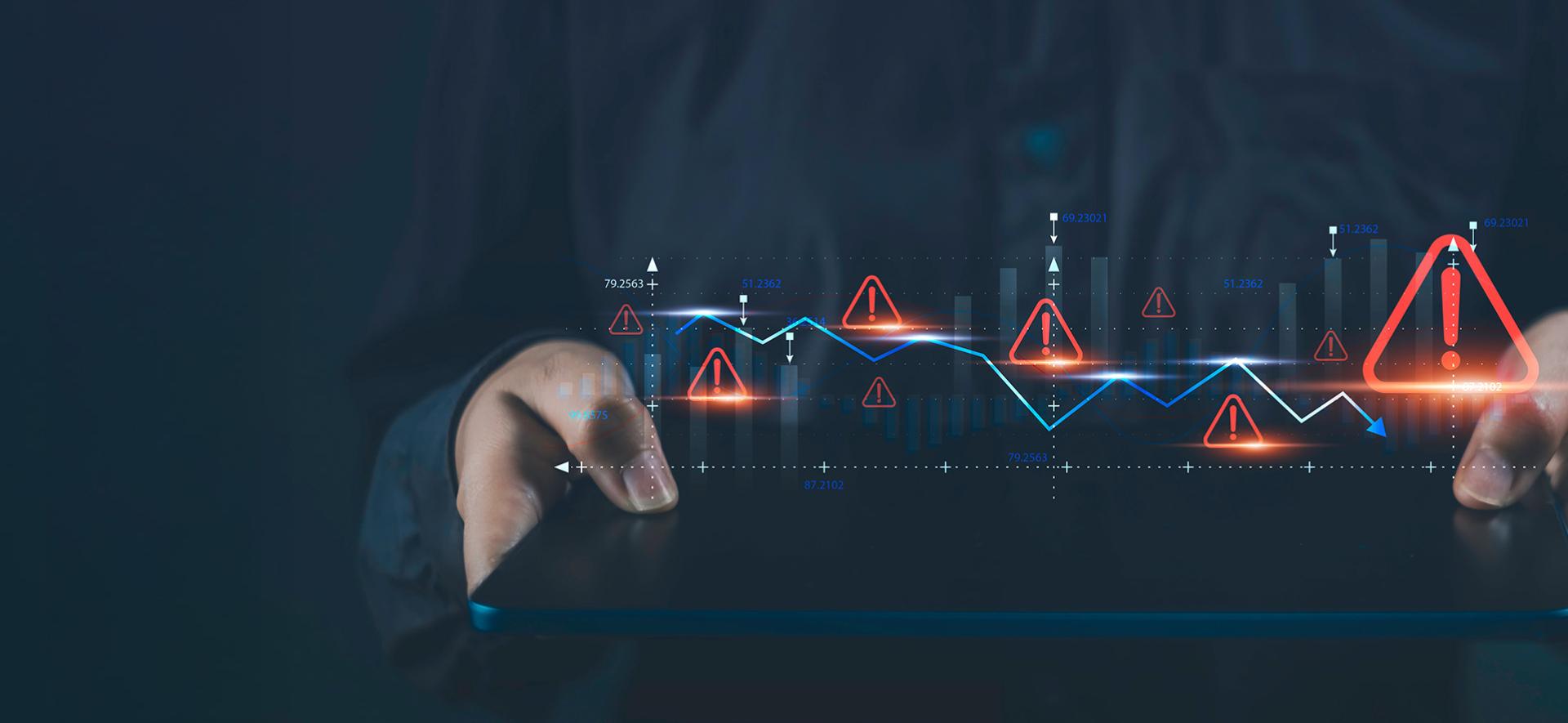 ręce trzymają poziomo tablet, a nad nim unoszą się ikony wykrzykników w trójkątach