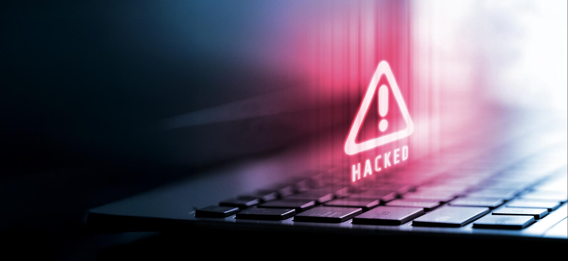 czerwony trójkąt z wykrzyknikiem unosi się nad klwiatura komputera