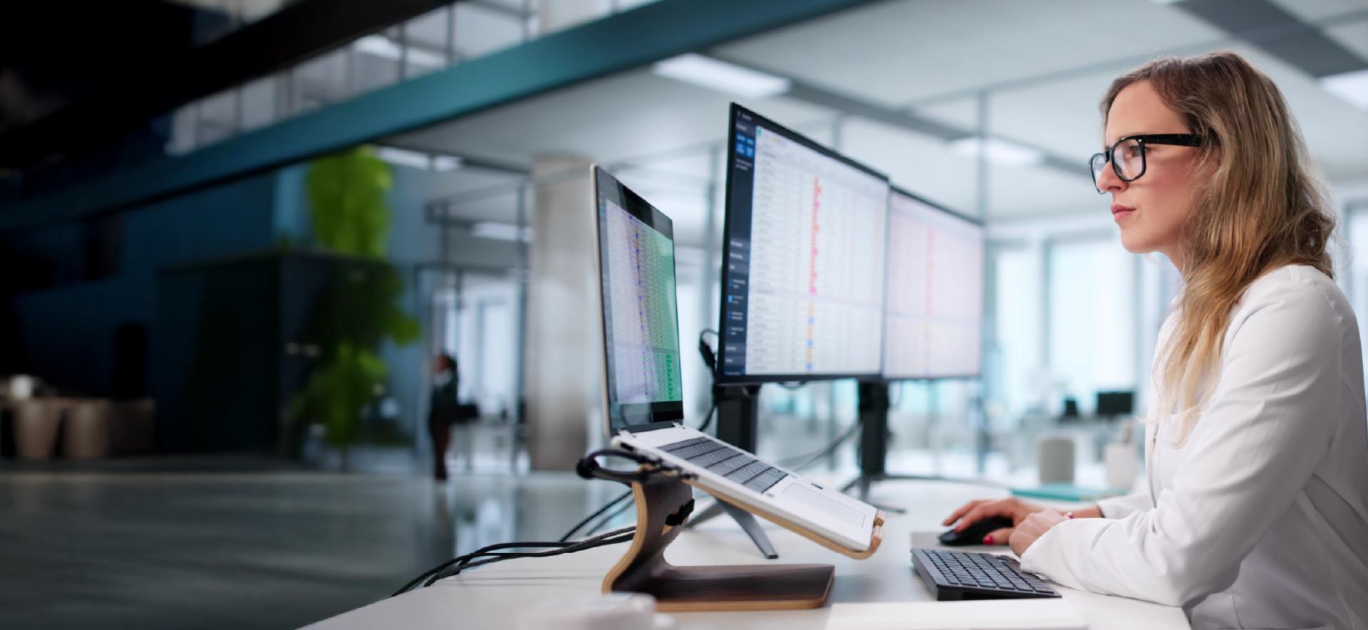 kobieta w okularach patrzy się w ekran komputera