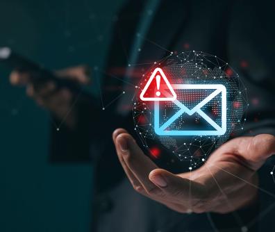 neonowa koperta z czerwonym wykrzyknikiem w rogu unosi się nad otwartą dłonią