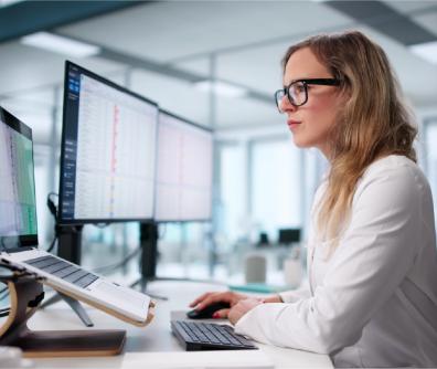 kobieta w okularach patrzy się w ekran komputera