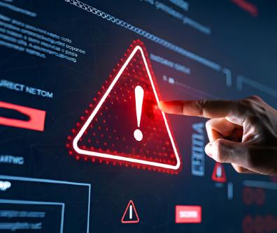 dłoń wskazująca na czerwony trójkąt z wykrzyknikiem