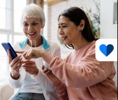 dwie kobiety patrzą na ekran smartfona