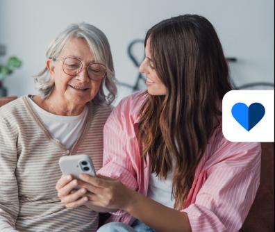 dwie kobiety patrzą na ekran smartfona