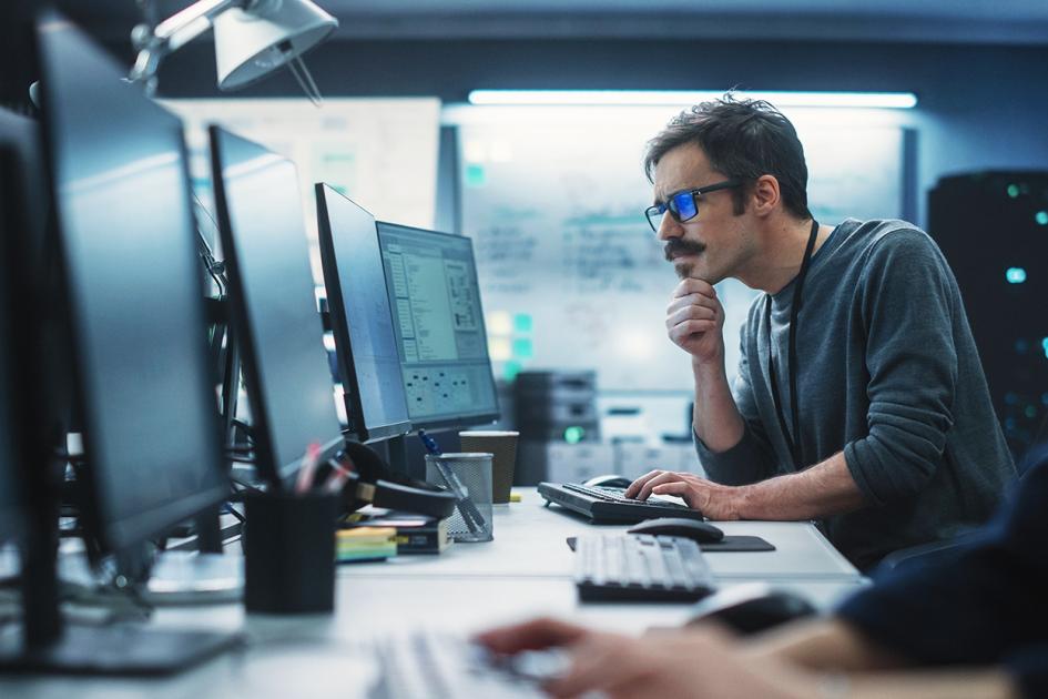 mężczyzna patrzący na monitor komputera