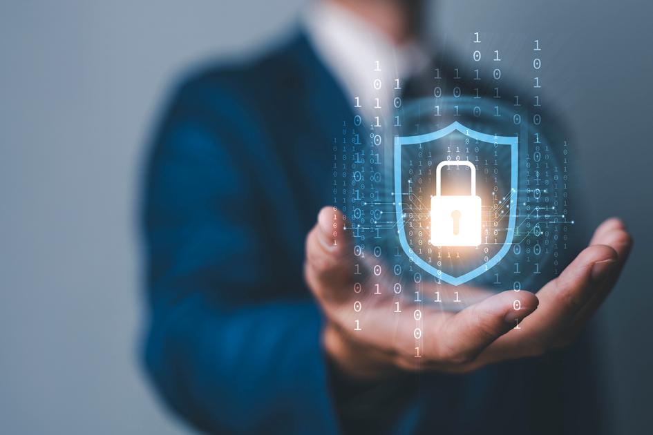 w tle tors człowieka, który wystawia rękę do przodu. Nad ręką unosi się ikona świecącej tarczy z kłódką.