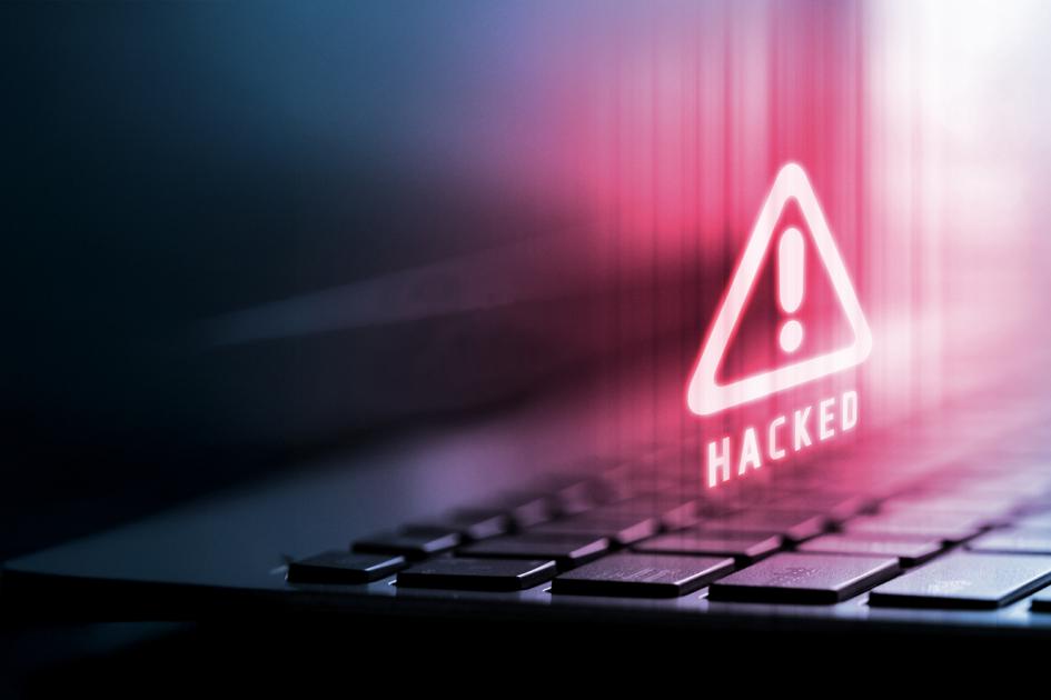 czerwony trójkąt z wykrzyknikiem unosi się nad klwiatura komputera