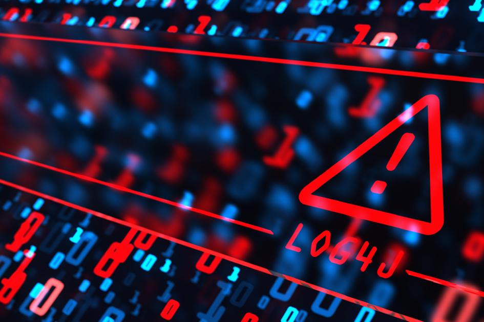 czerwony trójkąt z wykrzyknikiem w środku unosi się nad klawiaturą laptopa