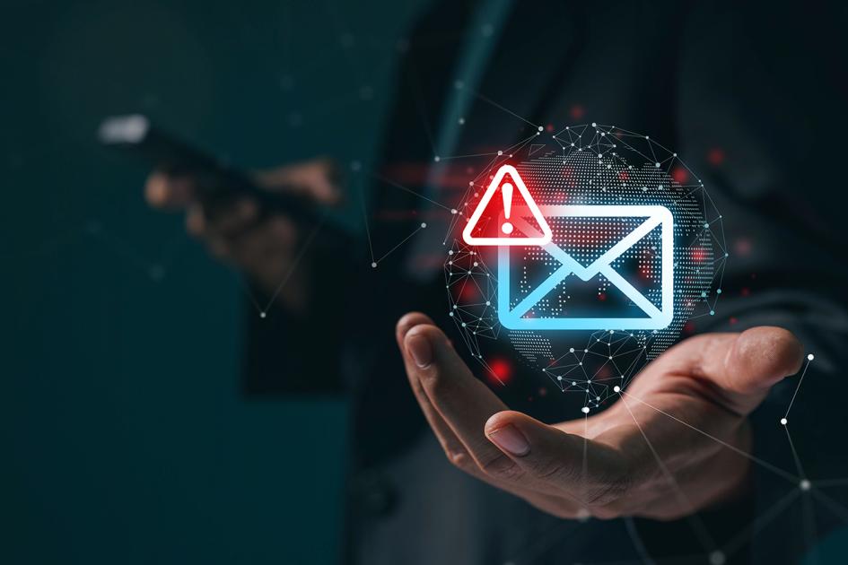 neonowa koperta z czerwonym wykrzyknikiem w rogu unosi się nad otwartą dłonią